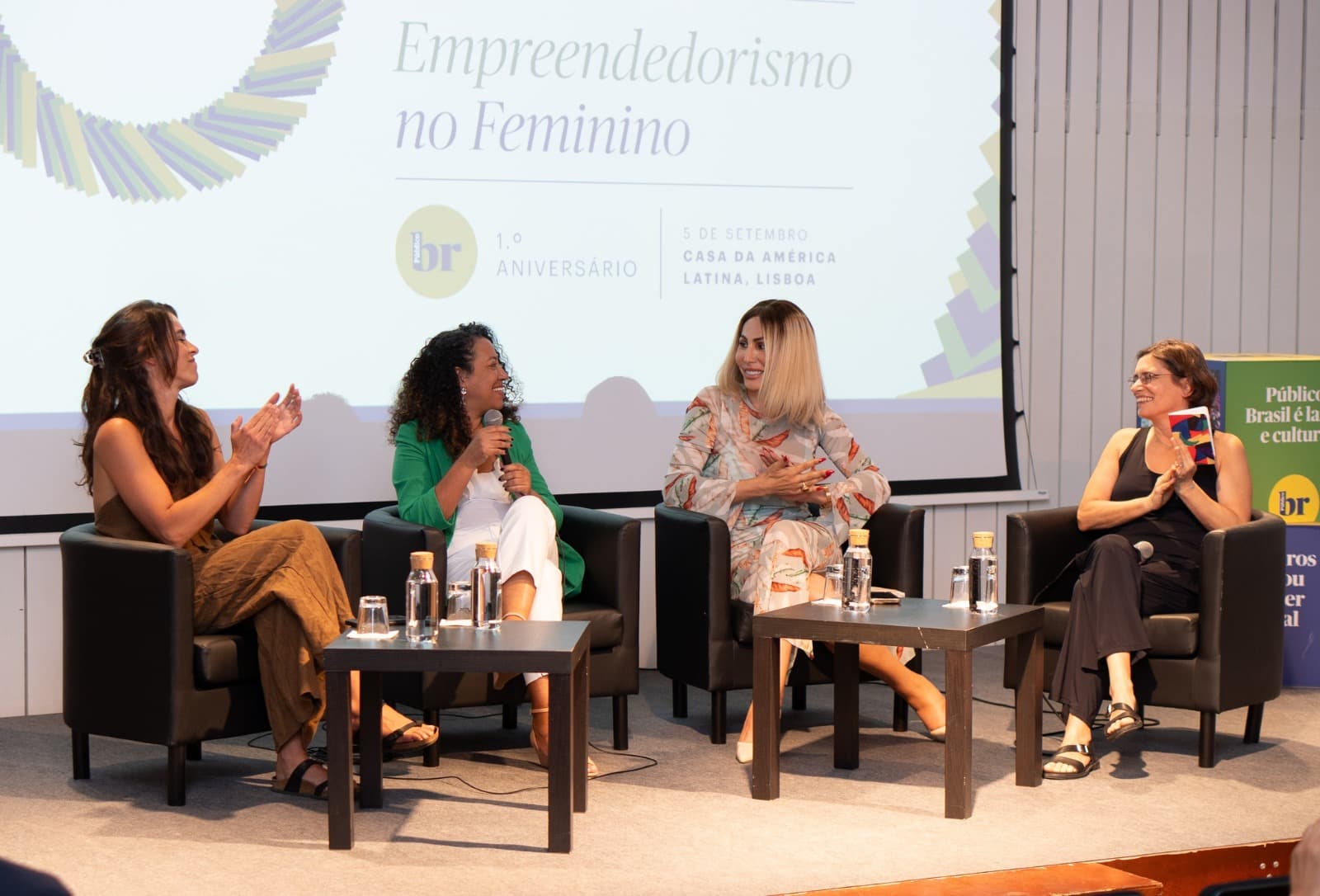 Elisangela Souza a participar num painel público, sentada em palco com os restantes intervenientes.